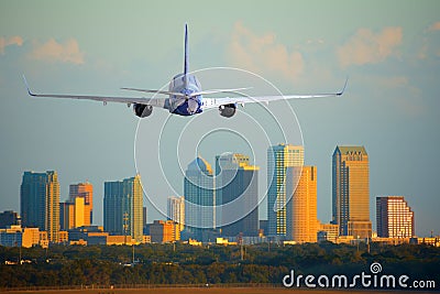 Passenger jet airliner plane arriving or departing Tampa International Airport in Florida at sunset or sunrise Stock Photo