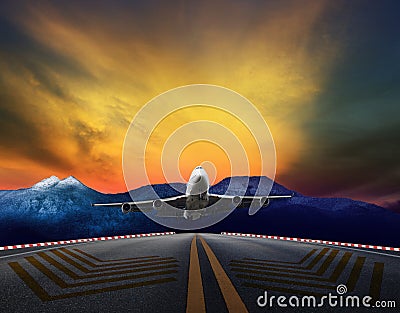 Passenger jet plane flying over airport runways against beautiful dusky sky Stock Photo