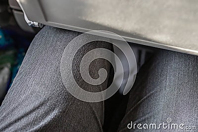 Passenger leg bump into back seat in low-cost commercial airlines. Narrow space for person knee in budget carrier airplane. Cheap Stock Photo