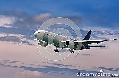 Passenger plane comes in to land on a blue sky Stock Photo