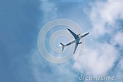 Passenger plane flies in sky, gaining height, bottom view. Stock Photo