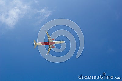 Passenger plane flying in the blue sunny sky, bottom view Stock Photo