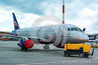 A passenger plane is standing at the airport in a parking space awaiting departure, the process of preparing for the flight is in Editorial Stock Photo