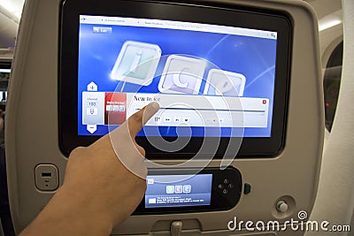 Passenger pointing at the touch screen in a plane Editorial Stock Photo