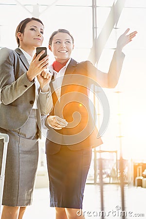 Passenger service agent assisting and giving directions with businesswoman in airport Stock Photo