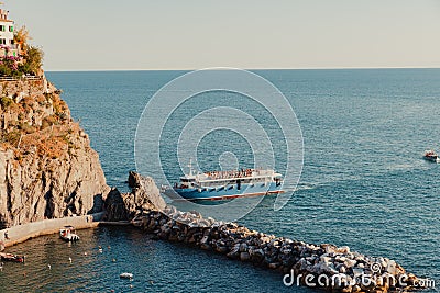 Passenger ship near the coastal village and cliff in Manarola, Italy Editorial Stock Photo