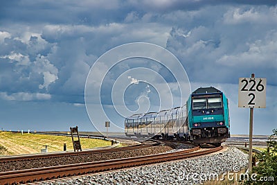 Passenger train on curved rail track under grey sky Editorial Stock Photo