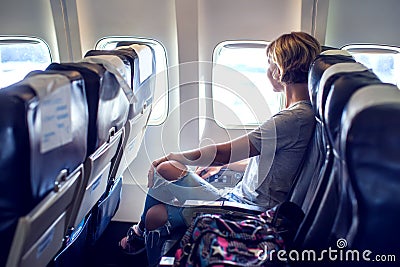 Passenger traveler looking at window in airplane, travel by flight, woman tourist sitting in air plane Stock Photo