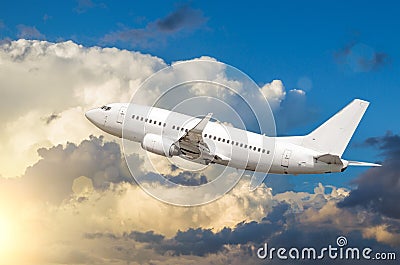Passenger white airplane takes off against a background of cumulus clouds at sunset. Stock Photo