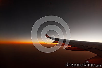Passengers commercial airplane flying above clouds in sunset light. Concept of fast travel, holidays and business. Stock Photo