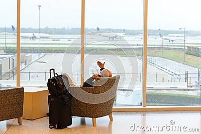 Passengers sitting with lugagge in airport Editorial Stock Photo