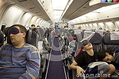 The passengers are sleeping in the cabin in flight Editorial Stock Photo