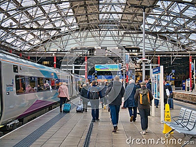 Passengers walk along the station platform after leaving the TransPennine Express train from Newcastle at Liverpool Editorial Stock Photo