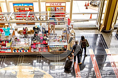 Passengers walking through a bright airport Editorial Stock Photo