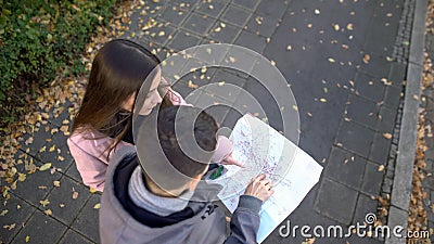 Passerby helping male tourist search destination place on city map, sightseeing Stock Photo