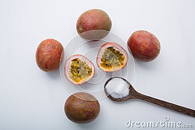 Passion fruit with salt in wooden spoon on wooden white background. Stock Photo