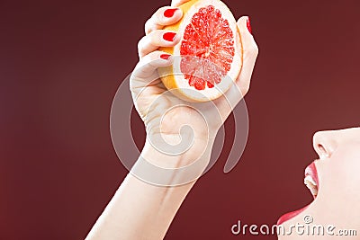 Passion Fruit Series. Closeup of Hand of Caucasian Girl Squeezing Grapefruit Stock Photo