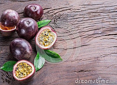 Passion fruits and its cross section with pulpy juice filled with seeds. Wooden background Stock Photo