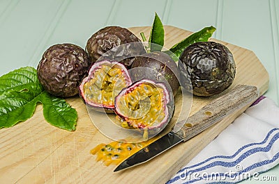 Passion fruits with leaves, knife and white flowers in jar Stock Photo