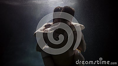 passionate embrace of loving pair underwater, young man and woman are hugging in depth of pool Stock Photo