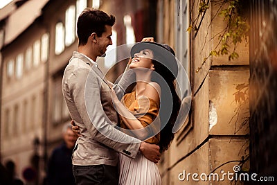 Passionate gorgeous young couple embrace each other while walk across ancient city. Cheerful elegant cute female model Stock Photo
