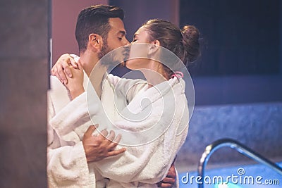 Passionate young couple kissing during a swimming pool spa center day - Romantic lovers having a tender moment on vacation Stock Photo