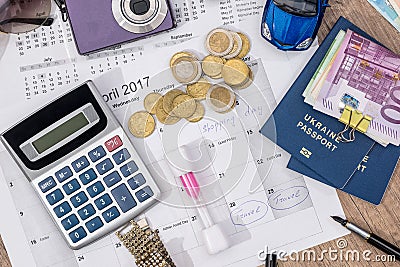 Passport, money, camera, watch, calculator, glasses, calendar toy car on wooden table. Stock Photo