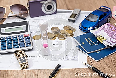 Passport, money, camera, watch, calculator, glasses, calendar toy car on wooden table. Stock Photo