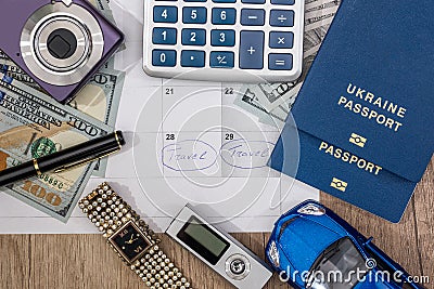 Passport, money, camera, watch, calculator, glasses, calendar toy car on wooden table. Stock Photo