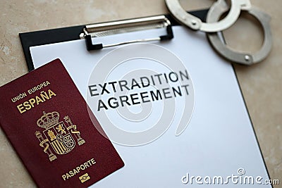 Passport of Spain and Extradition Agreement with handcuffs on table Stock Photo