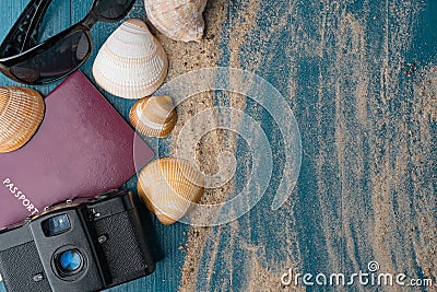 Passport, vintage camera, sunglasses and seashells with golden sand Stock Photo