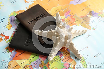 Passports and sea star on world map. Travel agency Stock Photo
