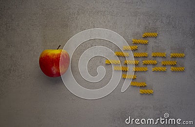 Pasta arrow points to an apple on a blue background Stock Photo