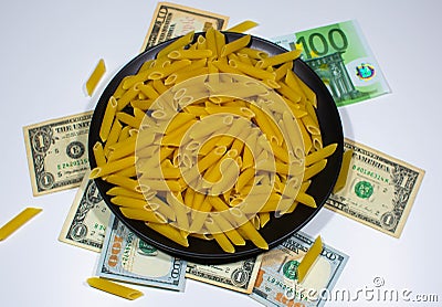 Pasta on a black plate under which lies money Stock Photo