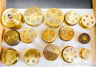 pasta dies extrusion shape brass pasta machine part golden stencil Stock Photo
