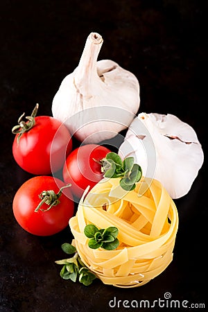 Pasta fettucciny with oregano and vegetable on black plate Stock Photo