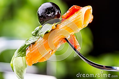 Pasta Penne with Tomato Bolognese Sauce, Parmesan Cheese black olive and Basil on a Fork. Mediterranean food.Italian cuisine Stock Photo