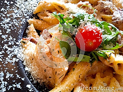 Pasta plate top view, macaroni with cherry tomato, salad and parmesan cheese. Close up food photo Stock Photo