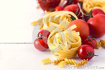 Pasta Products with Tomato Cheese Raw Pasta Fusili Fettuccine Ingredients Italian Food White Background Close Up Copy Space Toned Stock Photo