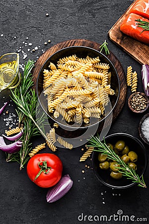Pasta, salmon fish and ingredients for cooking on black background, top view Stock Photo