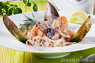 Pasta with seafood dish beautiful Italian food in still life shrimp shell mussel octopus dill Stock Photo