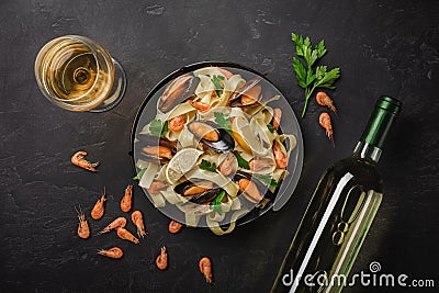 Pasta with seafood and white wine on stone table. Mussels and prawns. Top view Stock Photo