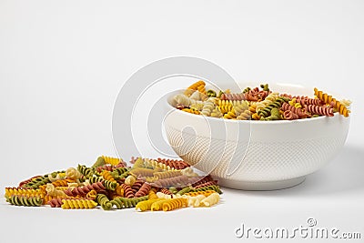 Pasta trottole tricolore wheat in a plate isolated on white background Stock Photo