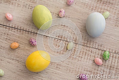 Pastel Colored Easter Eggs and Jelly Beans on White Wood Background Stock Photo