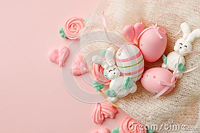 Pastel colored Easter eggs in nest, sweet tender decor from funny meringue and on pink background. Traditional springtime holiday Stock Photo