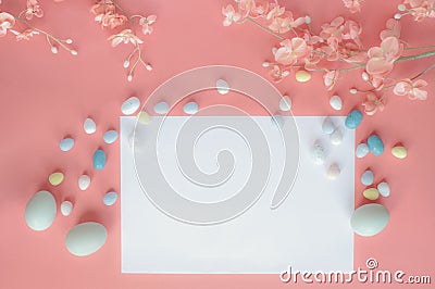 Pastel Easter Eggs Malt Candy Blank Card and Flowers over a Coral Colored Background Stock Photo