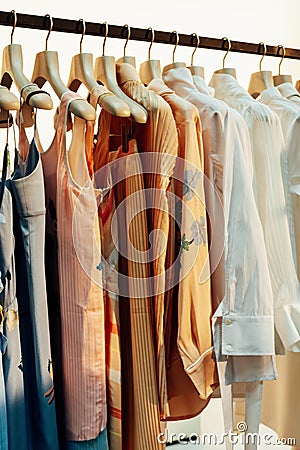 Pastel knit light summer dresses on white hangers Stock Photo
