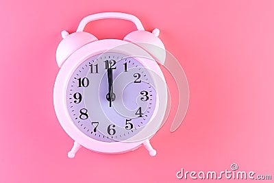 Pastel pink clock on pink painted wall. Minimal time concept. Chrismas eve or new year idea Stock Photo