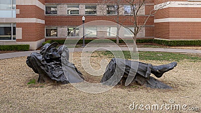 `Pastoral Dreamer`, a larger than life size bronze statue of a man lying in the grass on the campus of the University of Oklahoma. Editorial Stock Photo