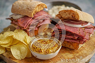 Pastrami sandwhich with delicious meet on baguette bread with chedder cheese, onion Stock Photo